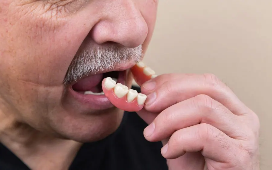 Elderly man holding his removable denture